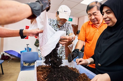 Residents and community gardeners learning to set up a worm bin